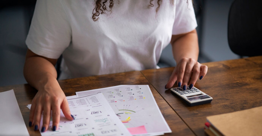 Empresária calculando tributos e analisando gráficos sobre tributação monofásica